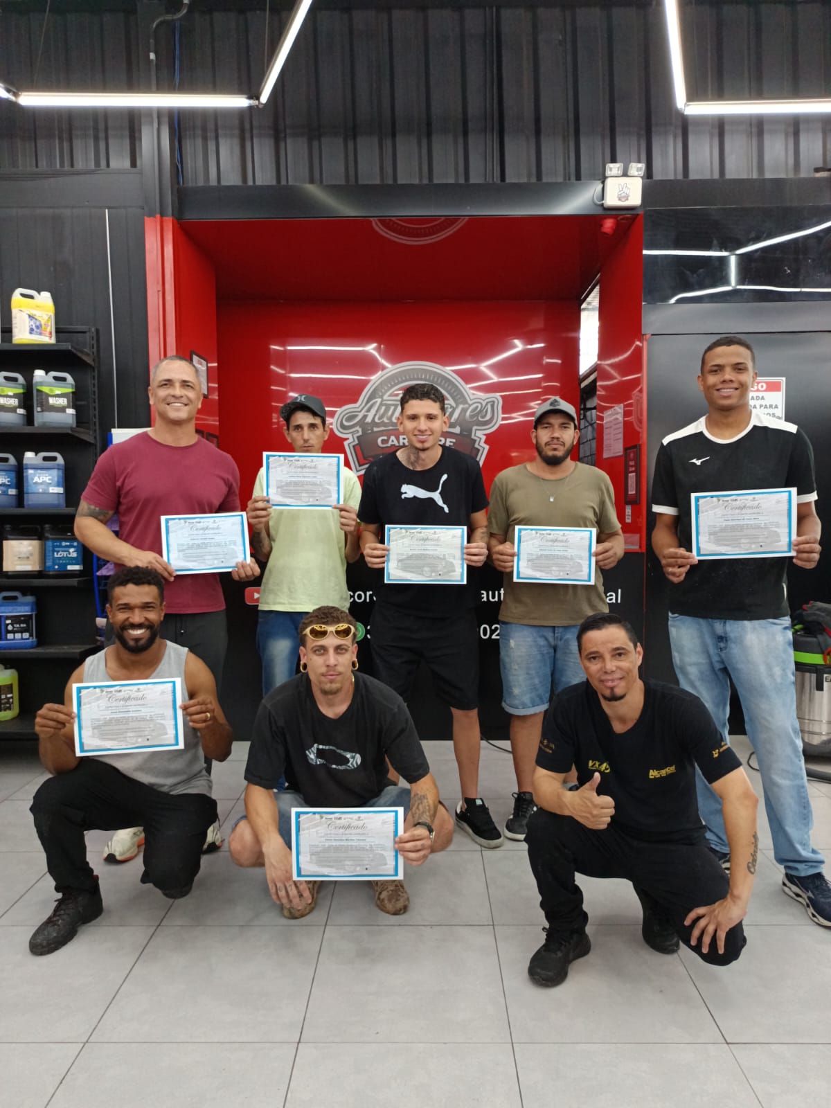 Turma de formação profissional em Estética Automotiva com os certificados de conclusão